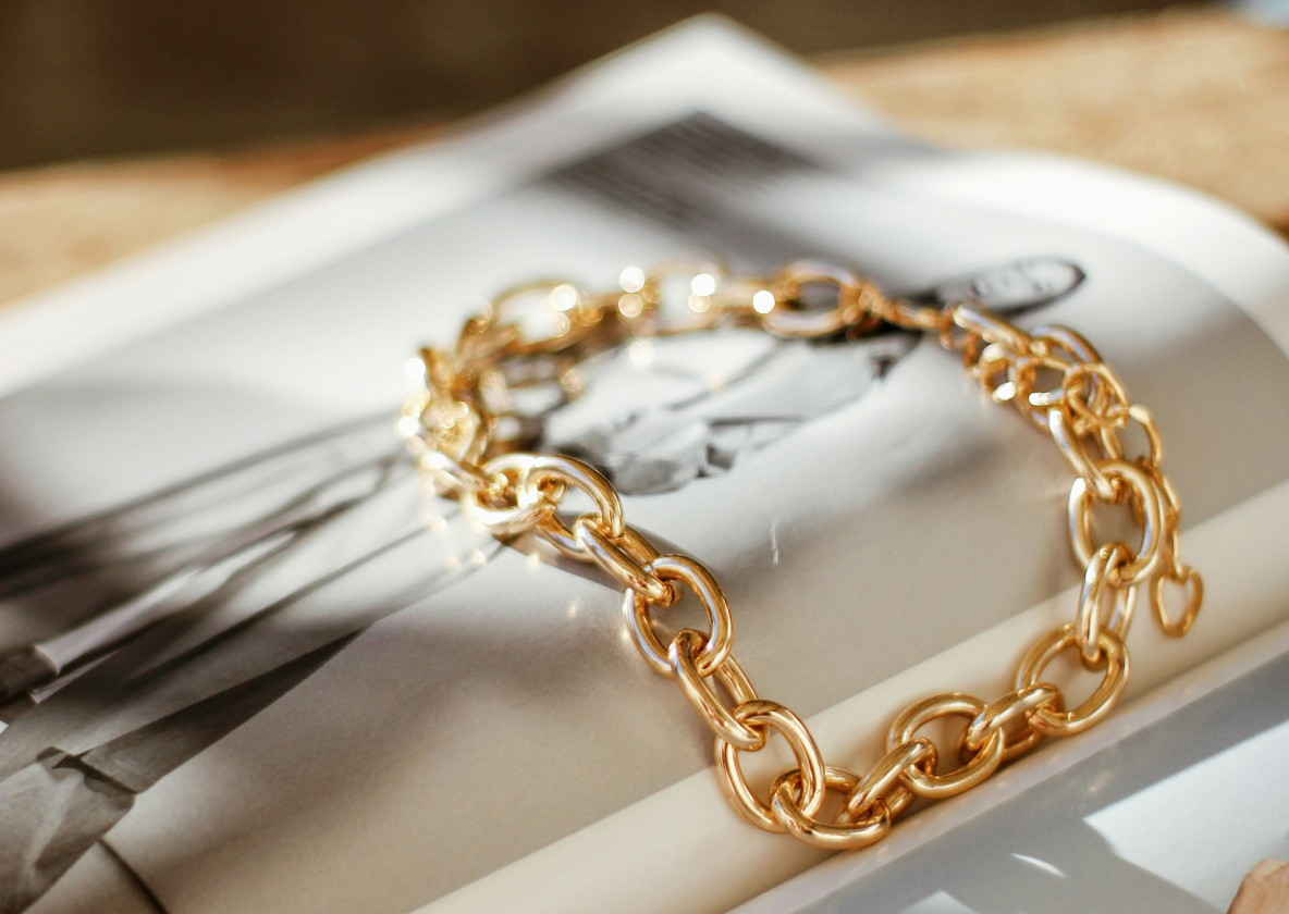 Gold chain bracelet resting on an open magazine