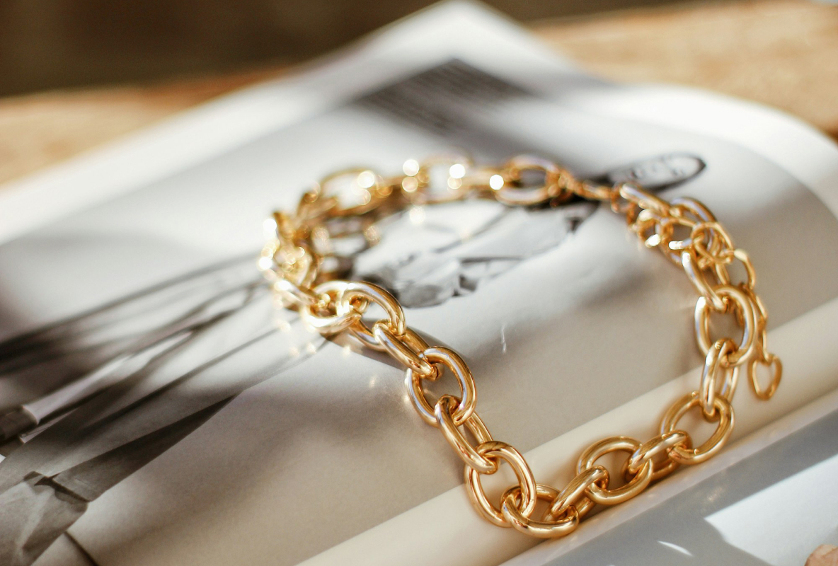 Gold chain bracelet resting on a magazine